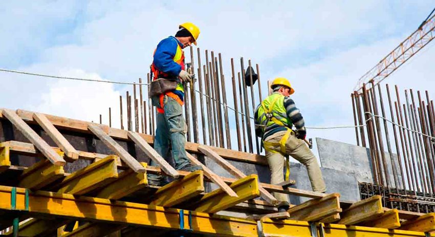 Descripción: Dos obreros trabajando en una construcción.